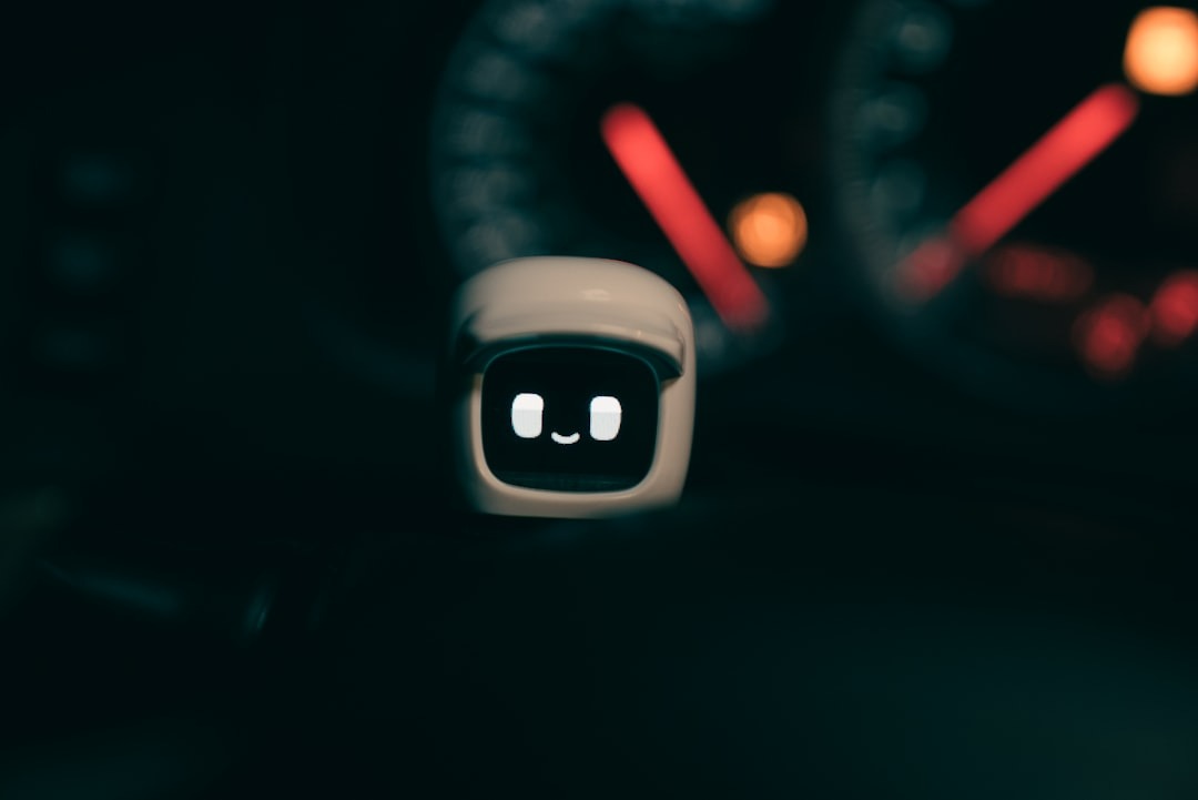 Small white cube robot displays a smiling face on its screen.